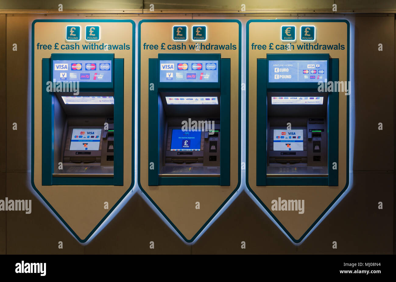 Cash withdrawl automated vending machines in a line, lit from 