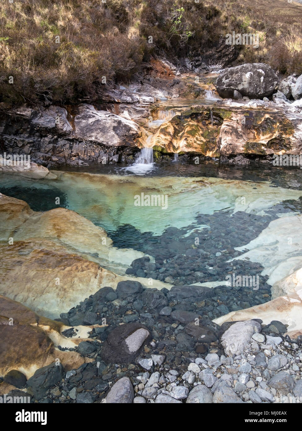 Rock pool eroded into Skye white marble slab in mountain stream bed of Allt Aigeinn, Torrin, Isle of Skye, Scotland, UK. Stock Photo