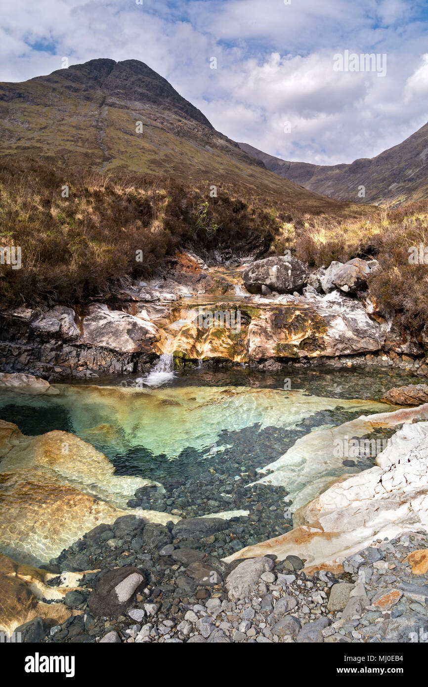 Rock pool eroded into Skye white marble slab in mountain stream bed of Allt Aigeinn with Sgurr nan Each beyond, Torrin, Isle of Skye, Scotland, UK. Stock Photo