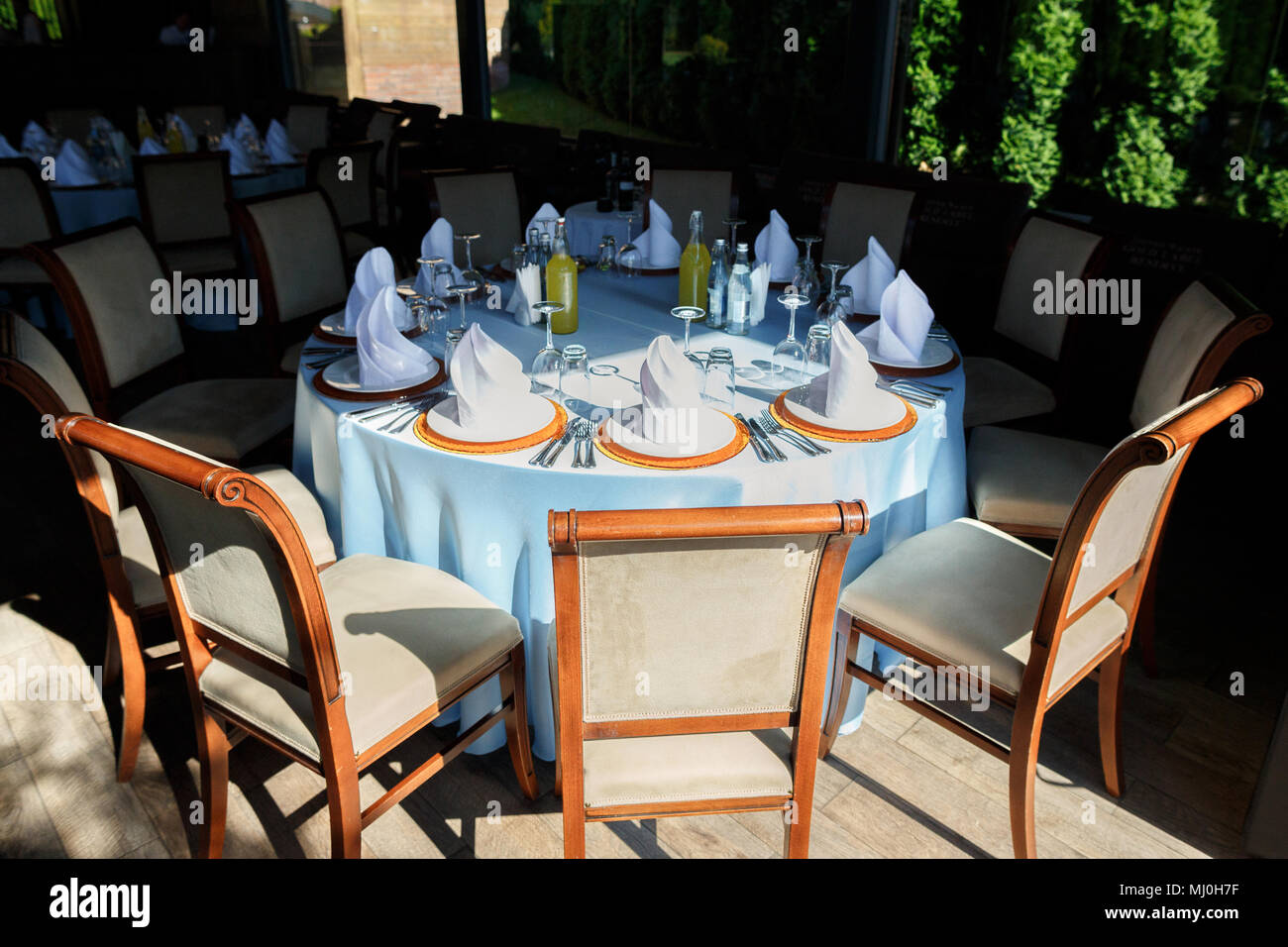 Served for a banquet catering table with wine glasses and plates for food Stock Photo
