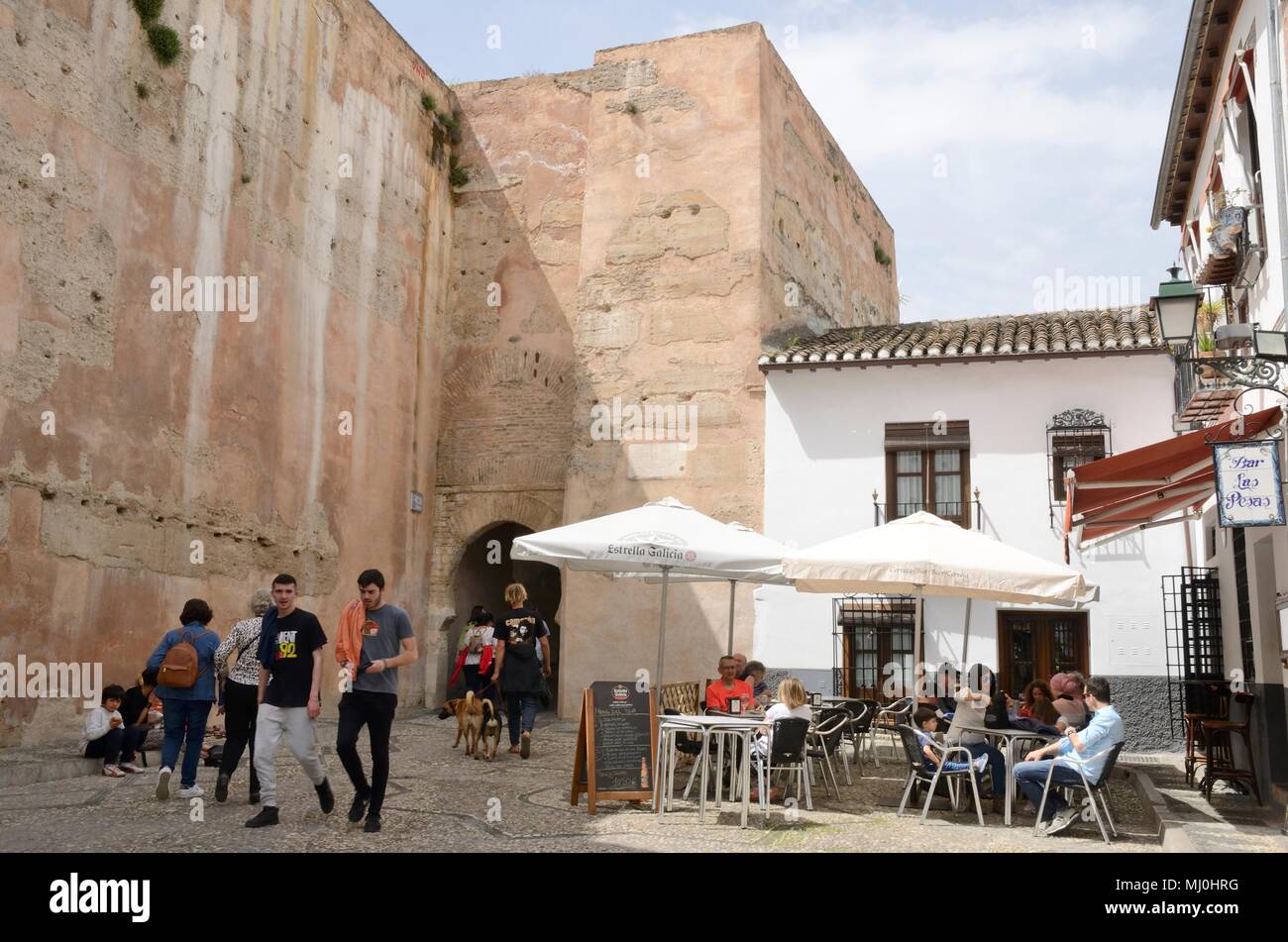 People at outdoors restaurant in plaza next to historical city gate in the Albaicin district of   Granada,  Andalusia, Spain. Stock Photo