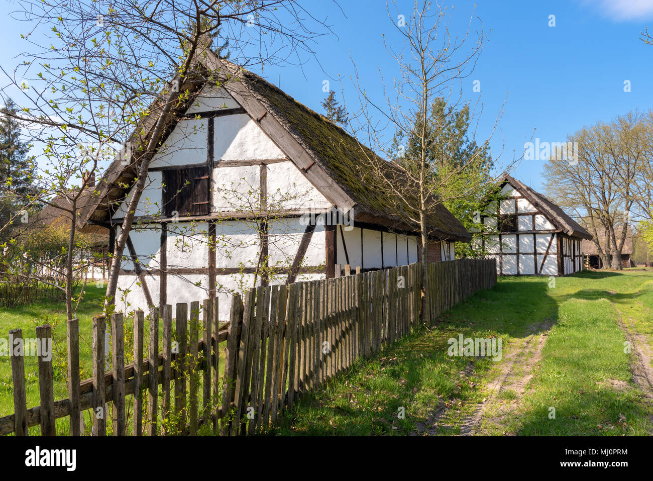 Typical traditional Polish country thatched house with white walls in