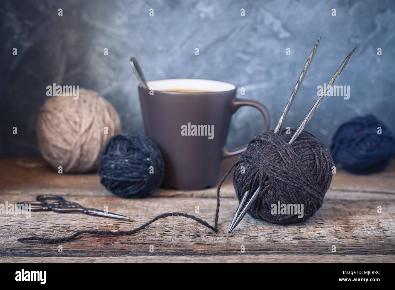 Beige, grey and brown yarn balls on a rustic wooden background, toned Stock Photo