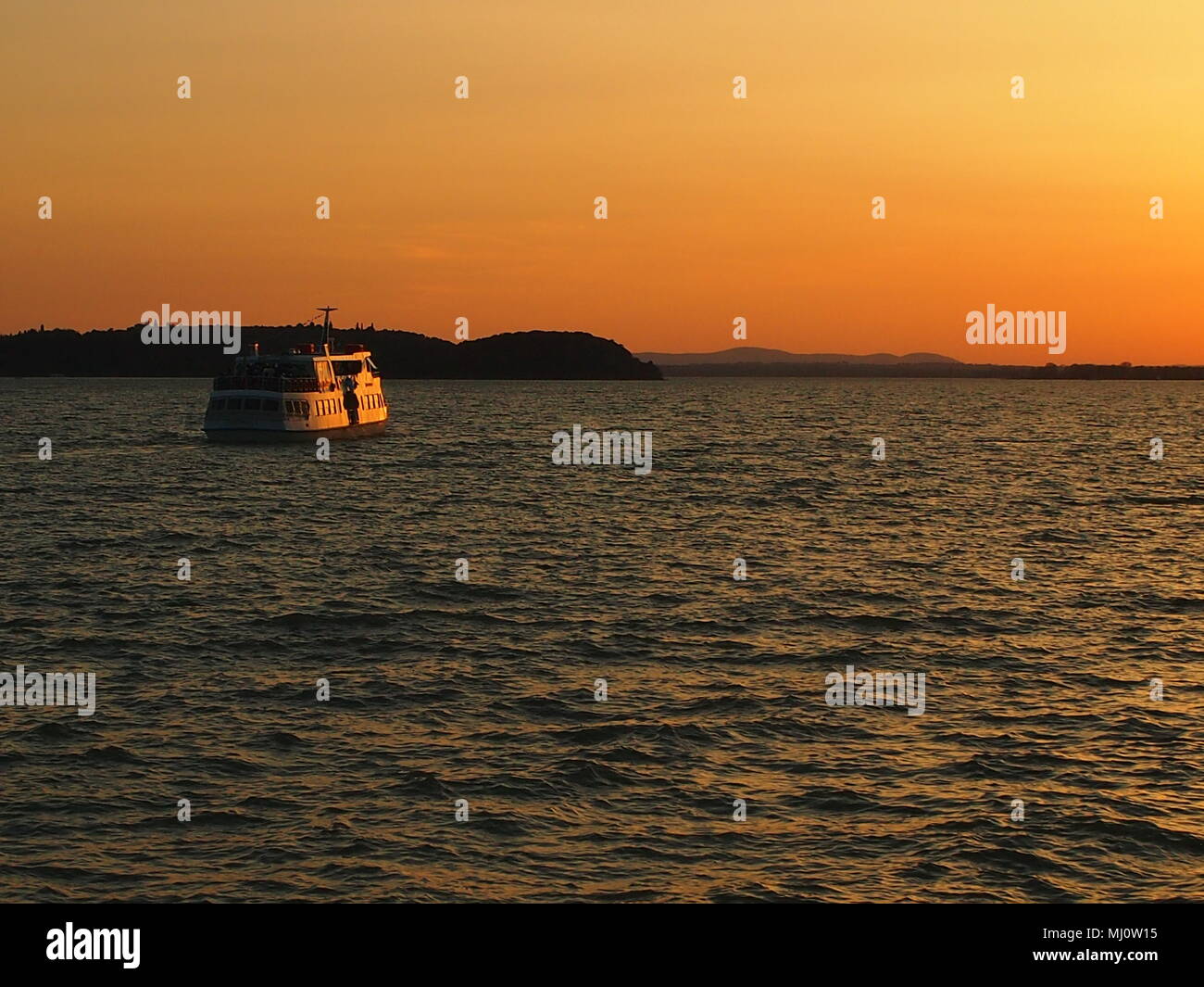 Dinner cruise sails into the sunset on Lake Trasimeno, Umbria, Italy Stock Photo