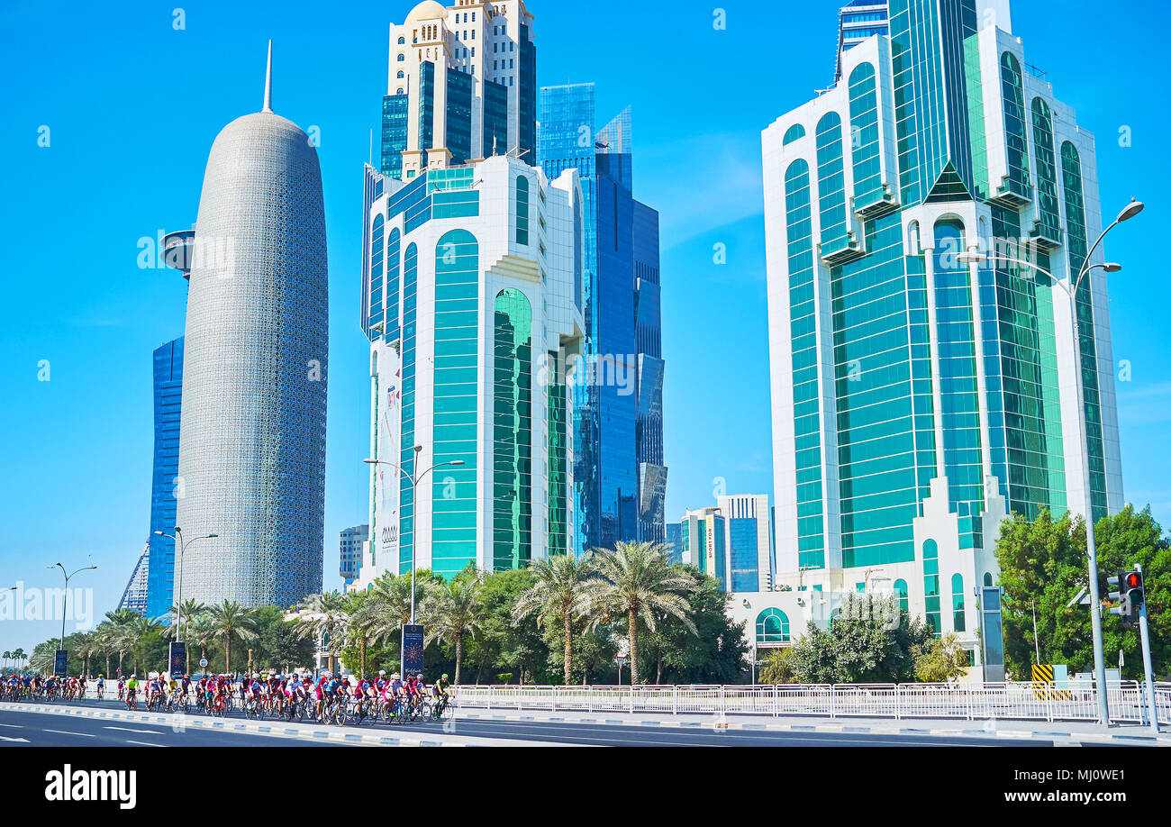 DOHA, QATAR - FEBRUARY 13, 2018: The cycle race in Doha is held in connection with the Day of Sport, cyclers ride along skyscrapers of Al Corniche str Stock Photo