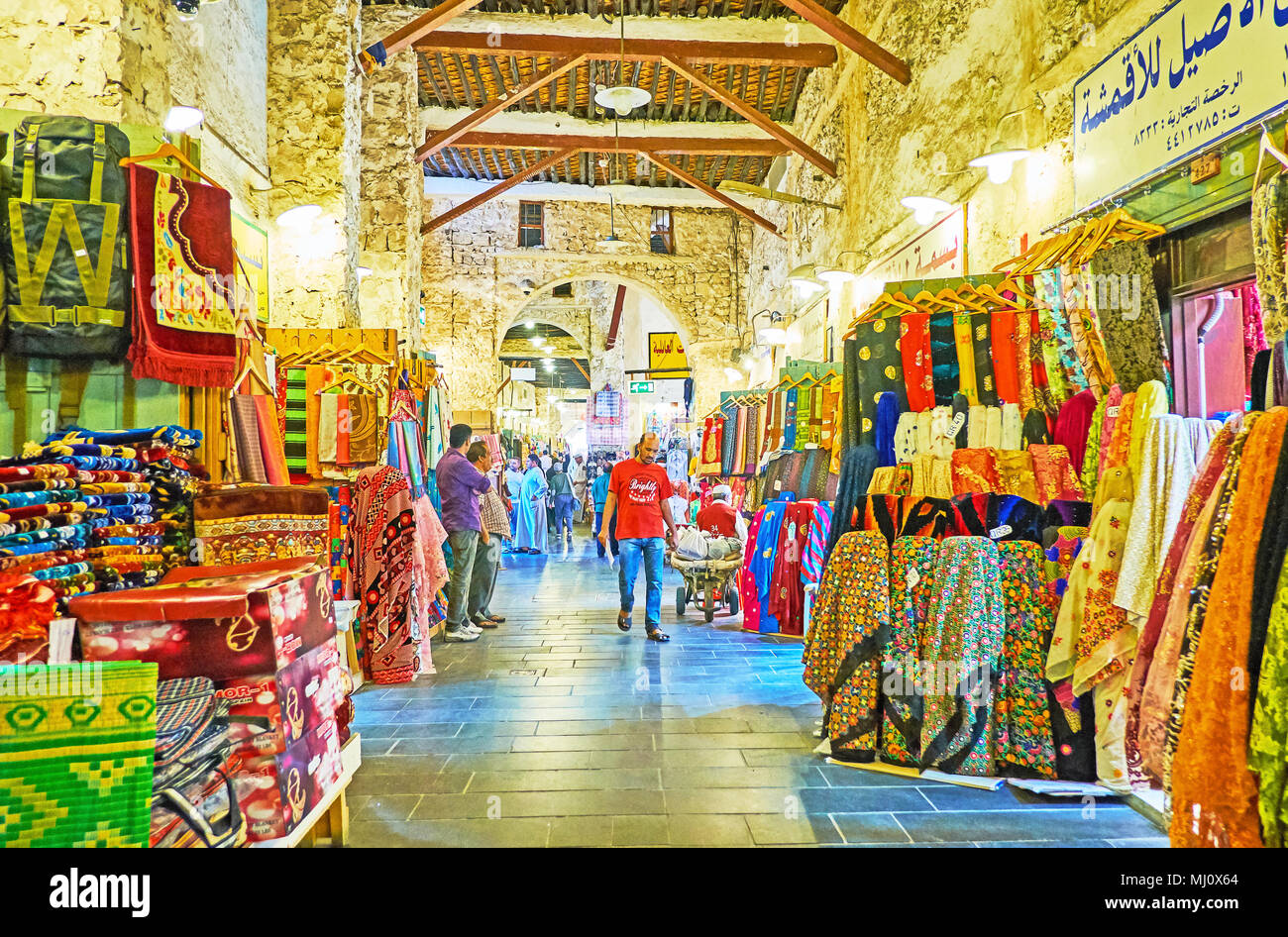 DOHA, QATAR - FEBRUARY 13, 2018: Textile department of  Souq Waqif, the stores in narrow medieval alleyway offer different fabrics, decorated with col Stock Photo