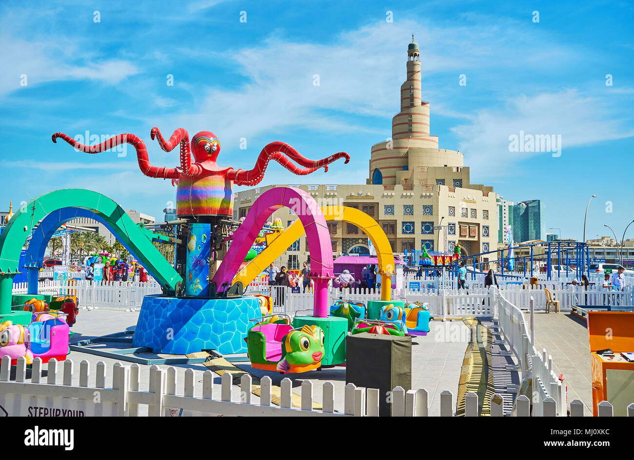 DOHA, QATAR - FEBRUARY 13, 2018: The scenic amusement park for kids is neighboring with Souq Waqif and Fanar Mosque, famous for the beautiful spiral m Stock Photo