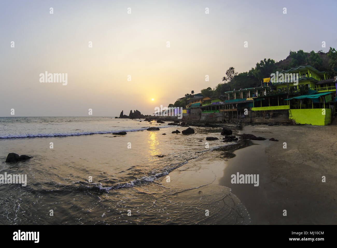Cafe on tropical rocky beach at sunset Stock Photo