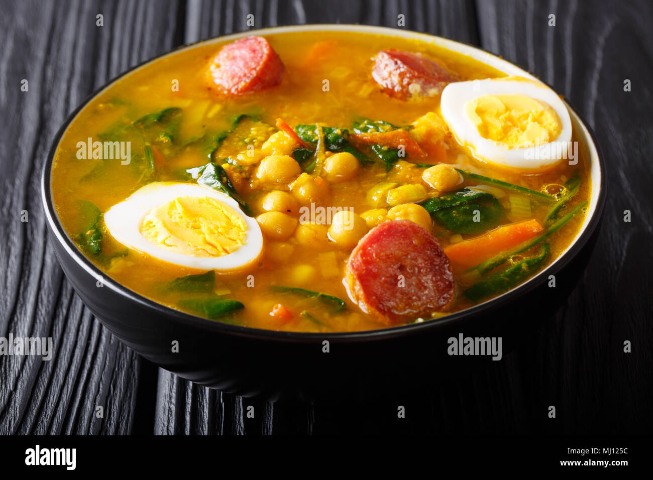 Traditional Spanish chickpeas with spinach, sausages chorizo, boiled