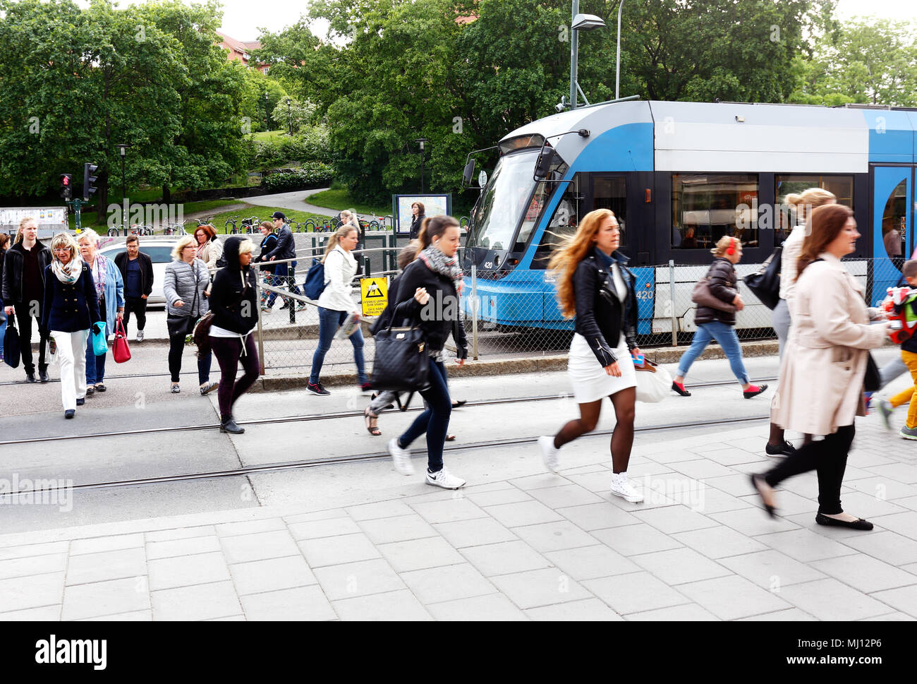 Stockholm, Sweden - June 10, 2015: Morning rush at tram stop at Liljeholmen with people walking from the tram at the public transport exchange hub Lil Stock Photo