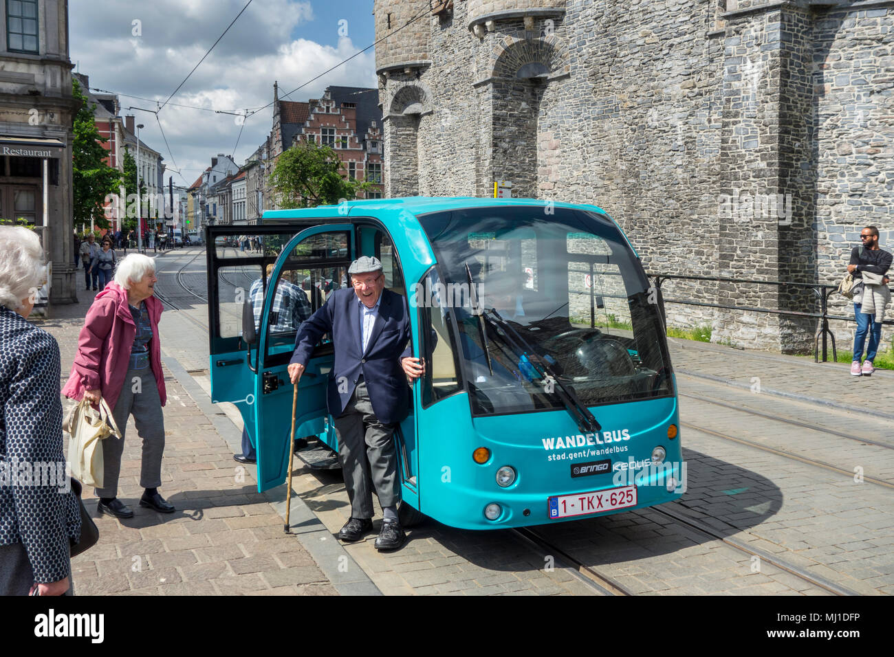 Elderly tourists stepping out of Keolis walking bus / Wandelbus, electric People Mover riding in the historic city centre of Ghent, Flanders, Belgium Stock Photo