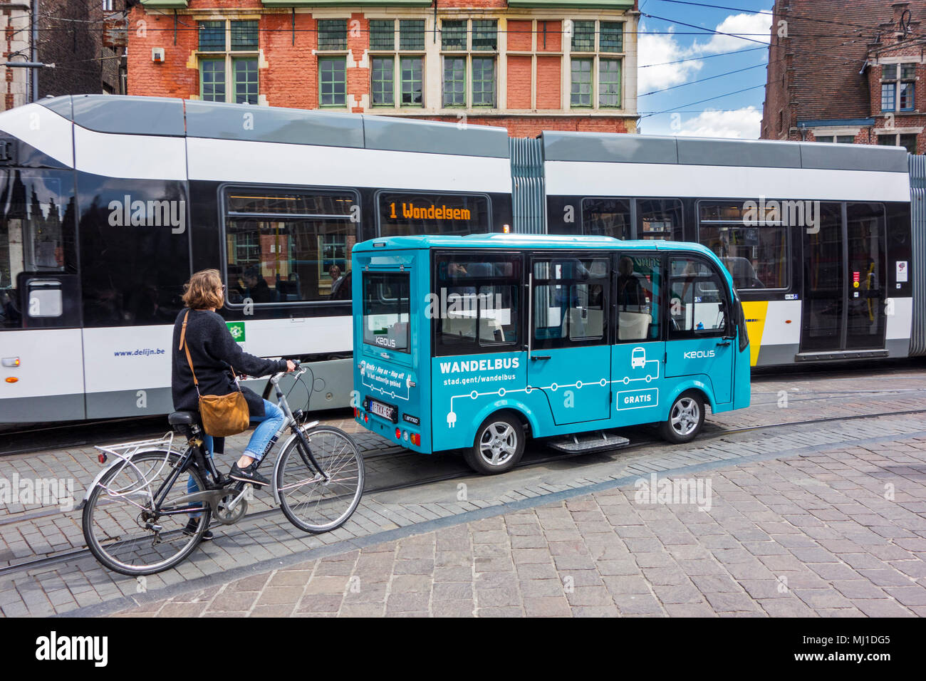 Keolis walking bus / Wandelbus, cyclist and tram riding in the pedestrianised area in the historic city centre of Ghent, East Flanders, Belgium Stock Photo