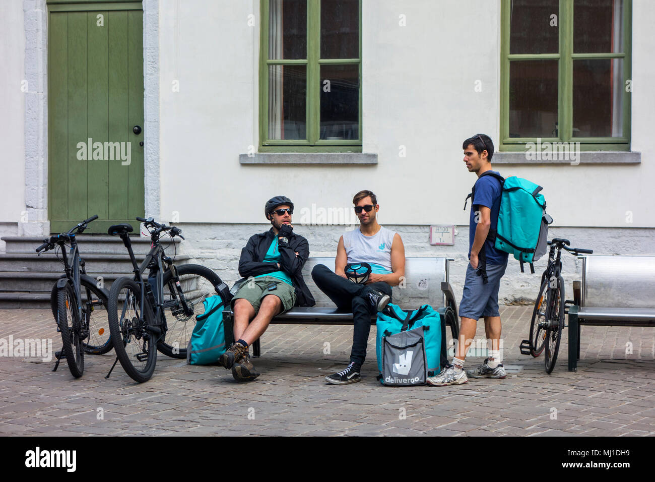 Bicycle couriers - working for Deliveroo, British online food delivery company - taking a break in city center Stock Photo