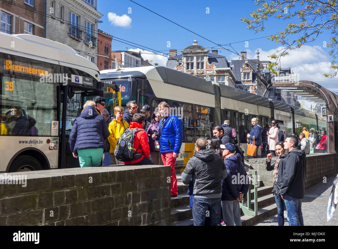 Tourists waiting for buses of De Lijn at bus stop in car free zone in the historic city centre of Ghent, East Flanders, Belgium Stock Photo