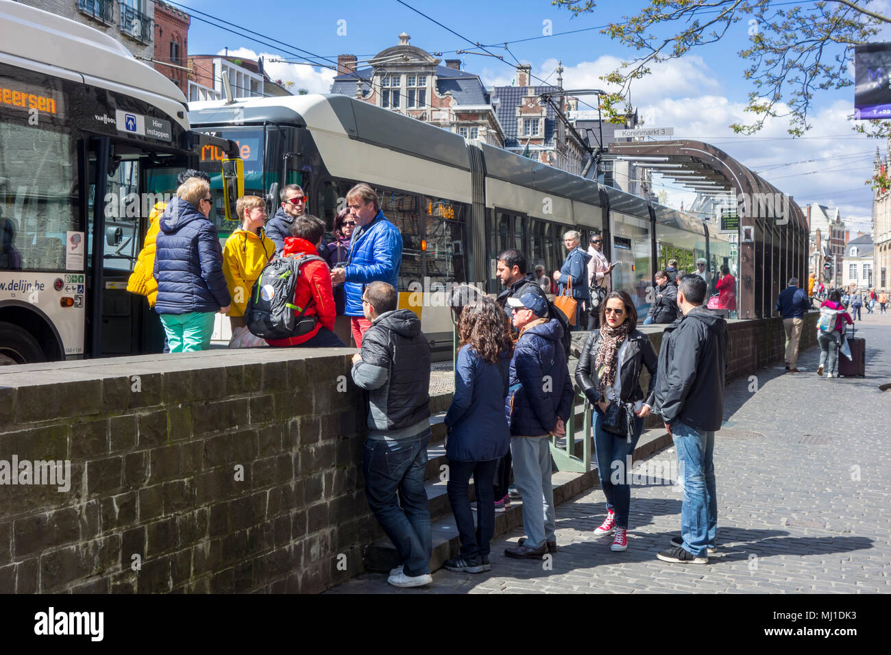 Tourists waiting for buses of De Lijn at bus stop in car free zone in the historic city centre of Ghent, East Flanders, Belgium Stock Photo