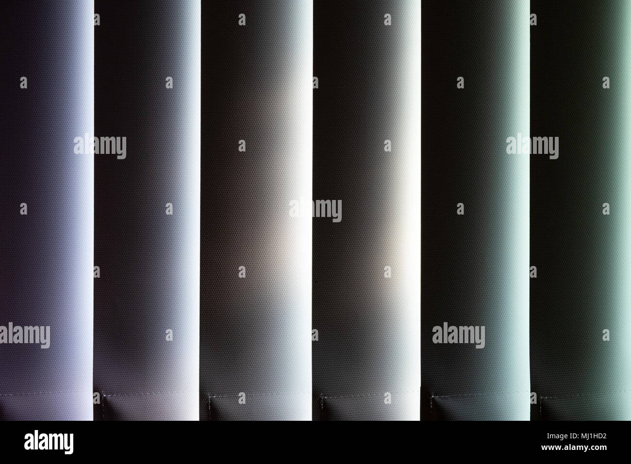 Vertical office blinds with sunlight shining through the gaps Stock