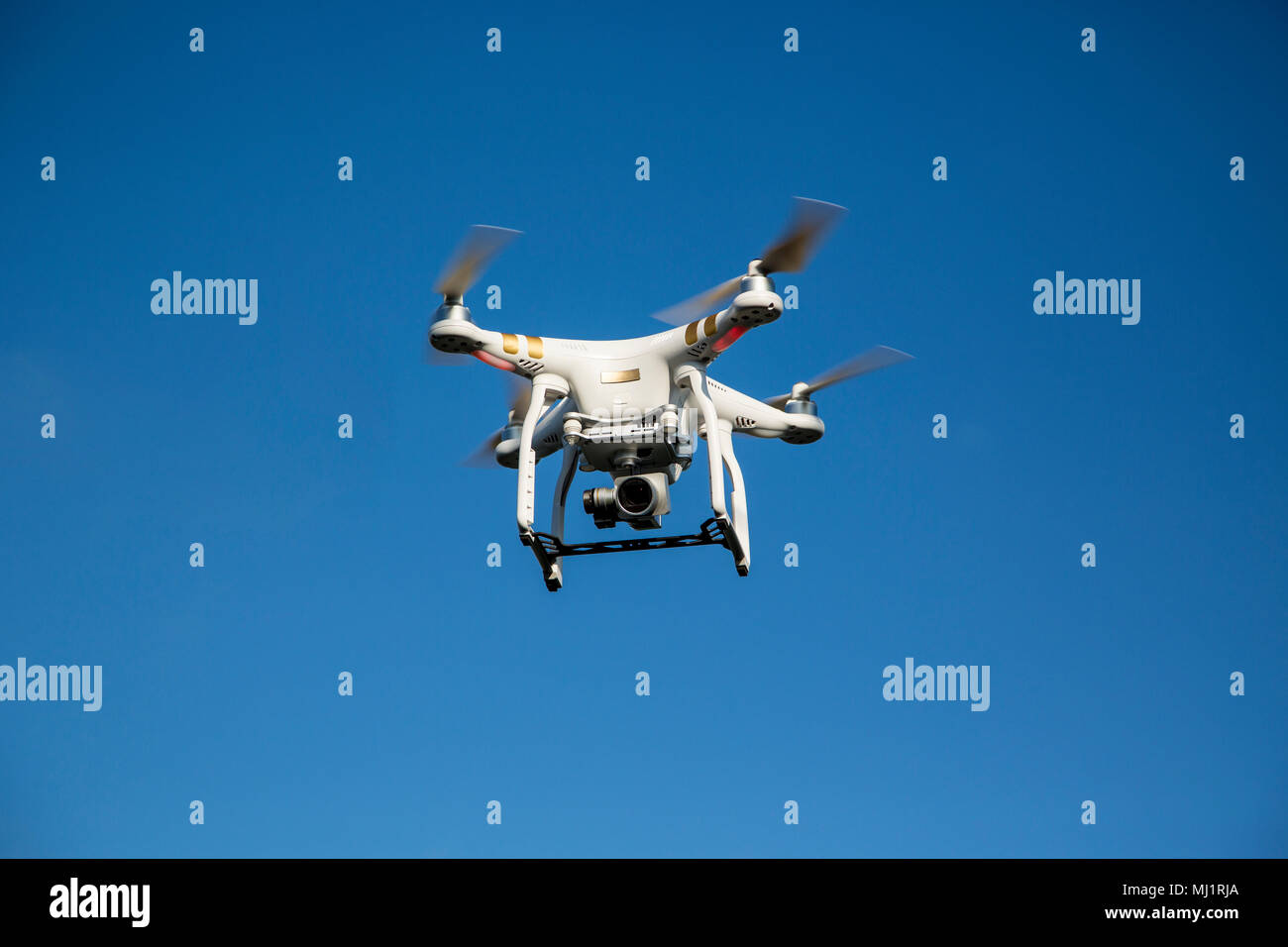 Drone in flight against blue sky Stock Photo