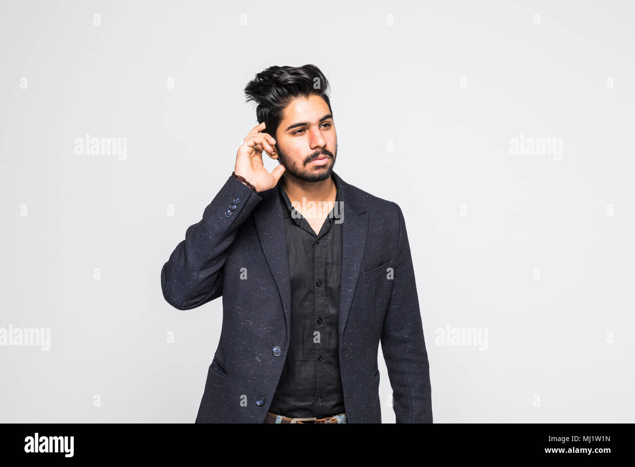 Closeup portrait of handsome indian guy trying to secretly listen in on a conversation, privacy violation, isolated on white background Stock Photo