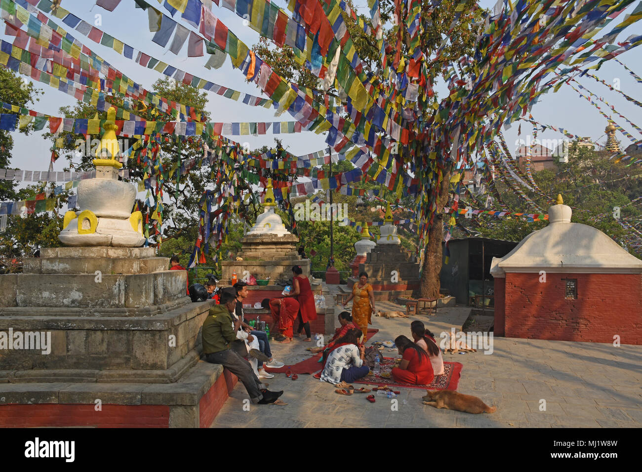 Kathmandu, Nepal - March 23, 2018: Family in traditional hindu clothes are having picknick at Swayambhunath Stupa Stock Photo