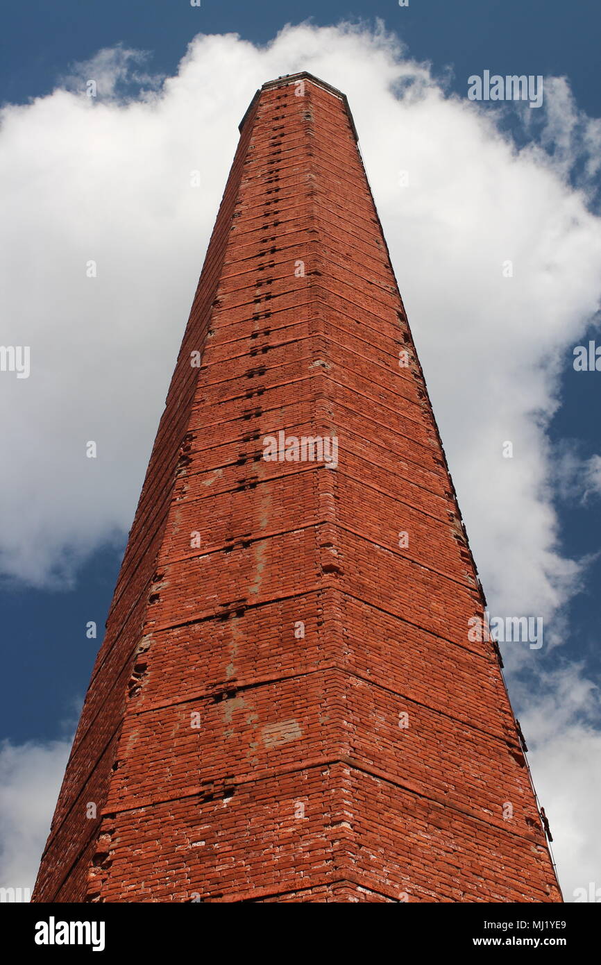 industrial chimney of red brick against a blue sky Stock Photo