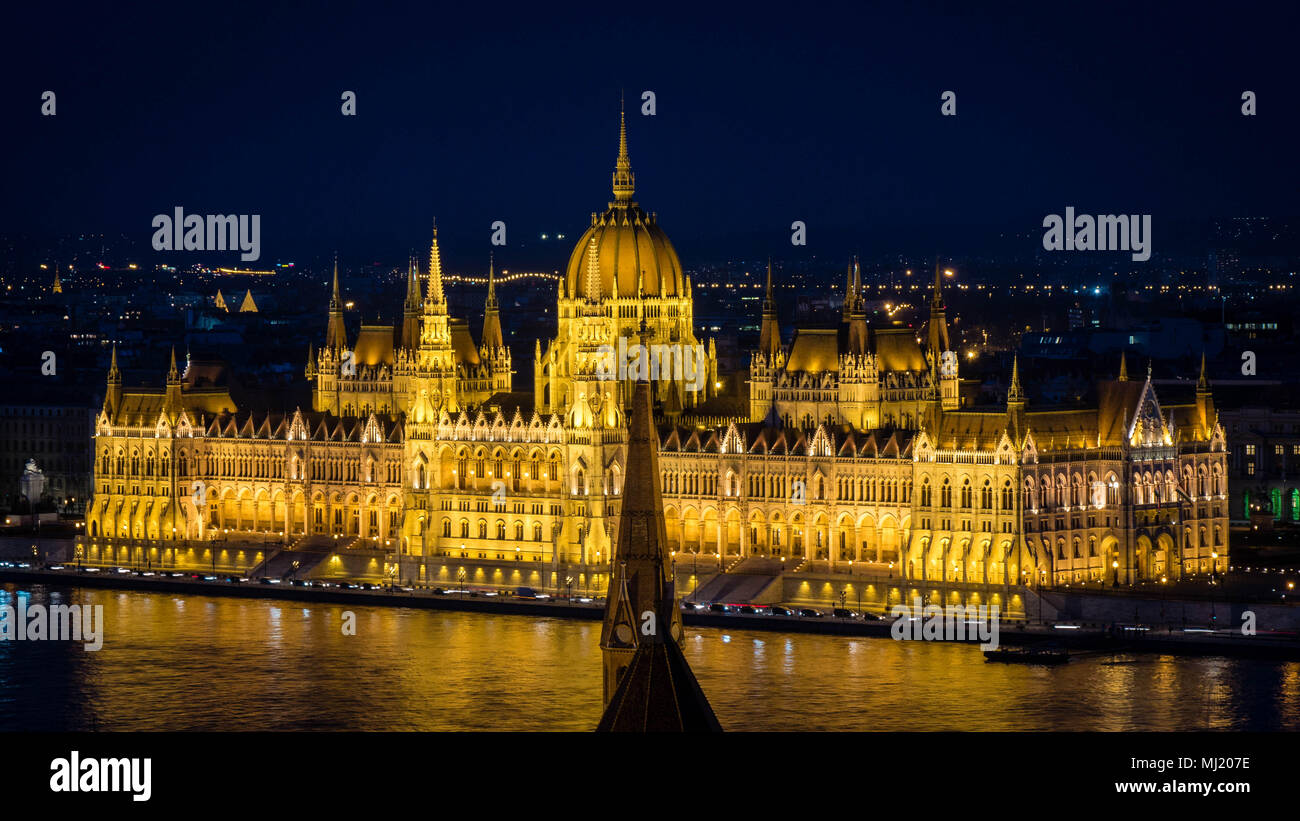 Golden Parliament of Budapest at night up close seen from opposite river bank Stock Photo