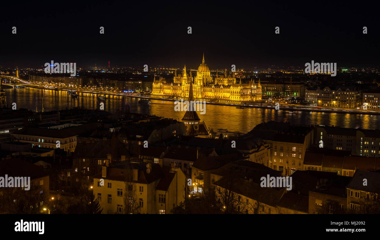 Golden Parliament of Budapest with river Danube and city houses on opposite river bank Stock Photo