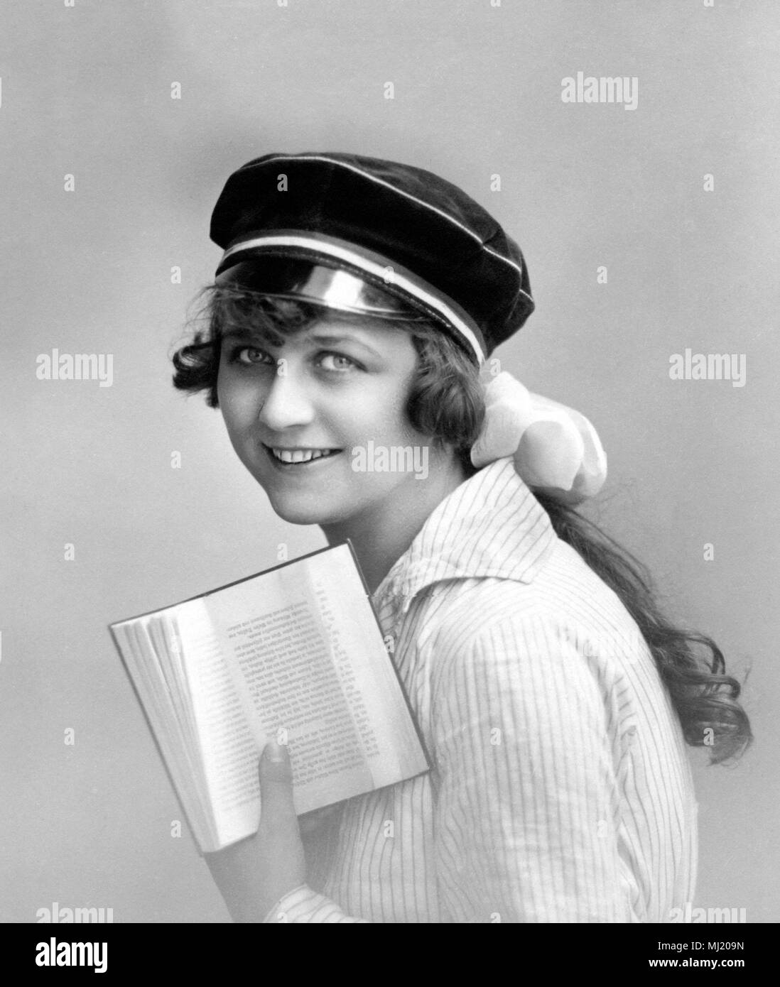 Woman with student hat reading a book, 1920s, Germany Stock Photo