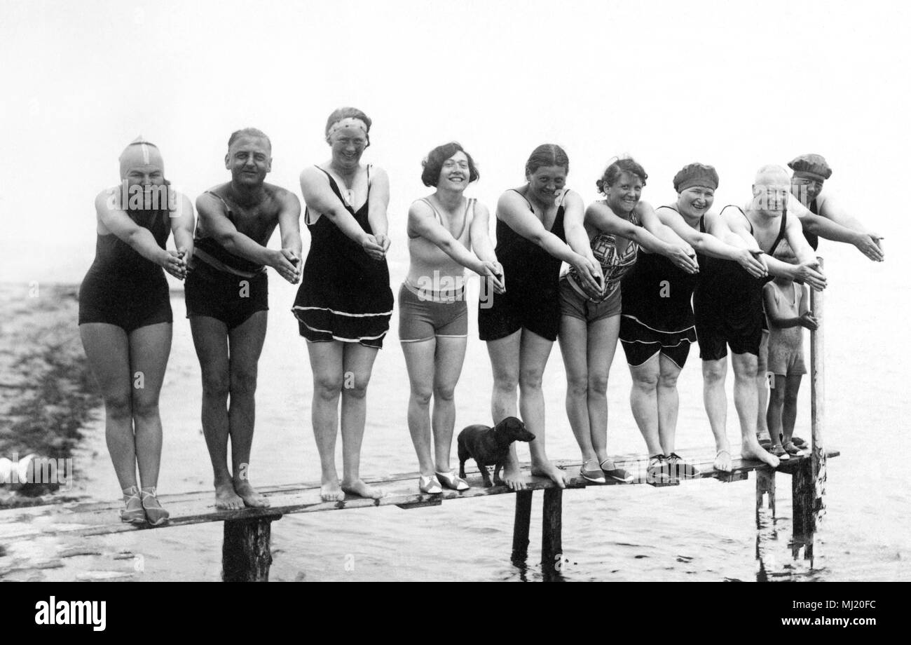 Swimwear, holidays, nine men and women and a dachshund posing on a