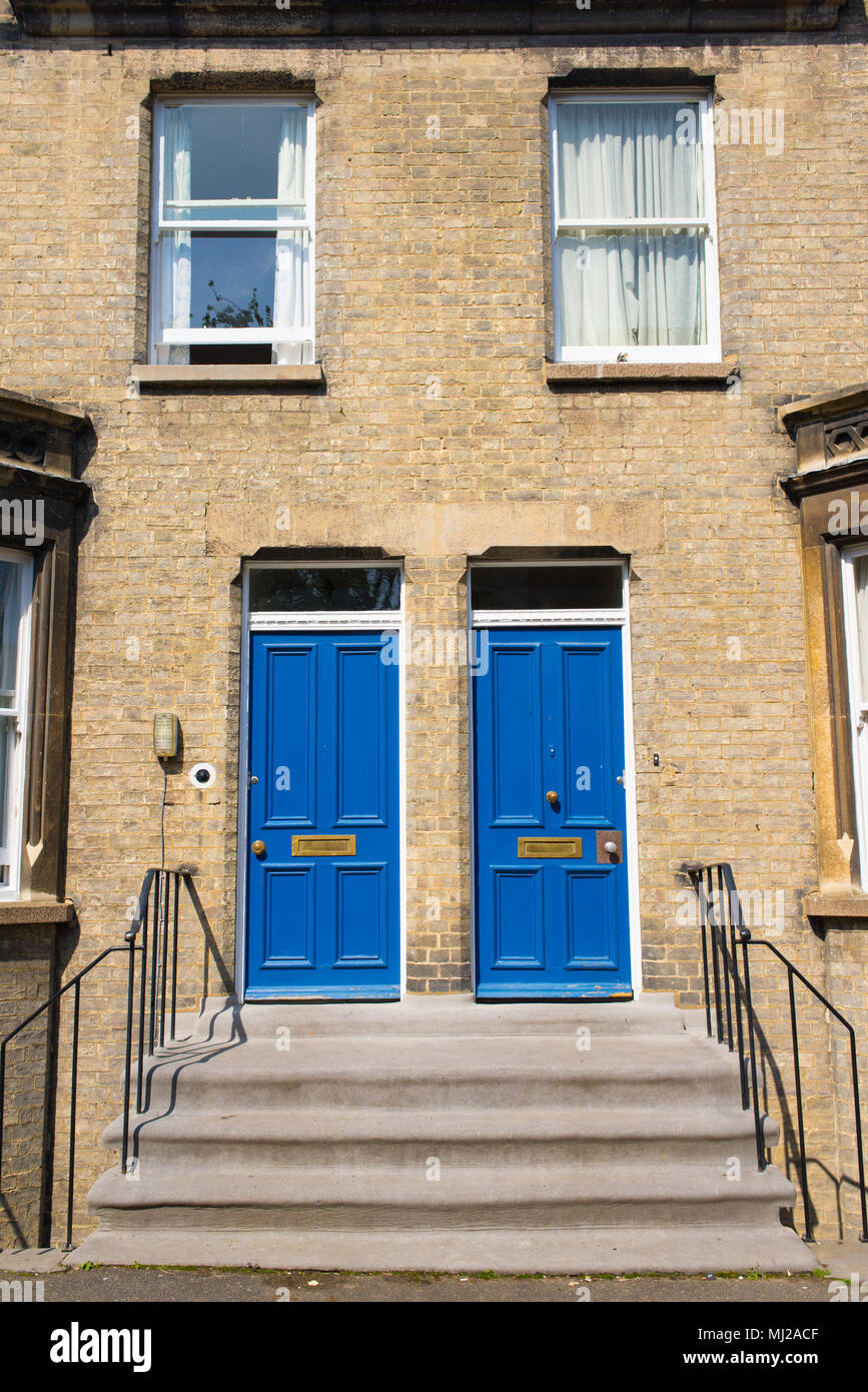 Two identical blue wooden front doors at the entrance of a classic Victorian british style house Stock Photo