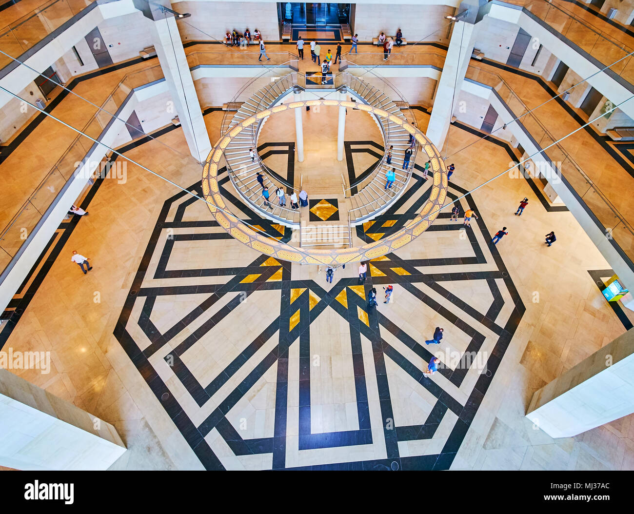 DOHA, QATAR - FEBRUARY 13, 2018:  The contrast of circular chandelier and half-round staircases with stellar tile pattern on the floor of Islamic Art  Stock Photo