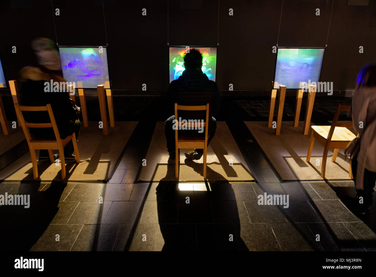 A man sat on a chair looking at a hologram display in Montreal Fine Arts museum Stock Photo
