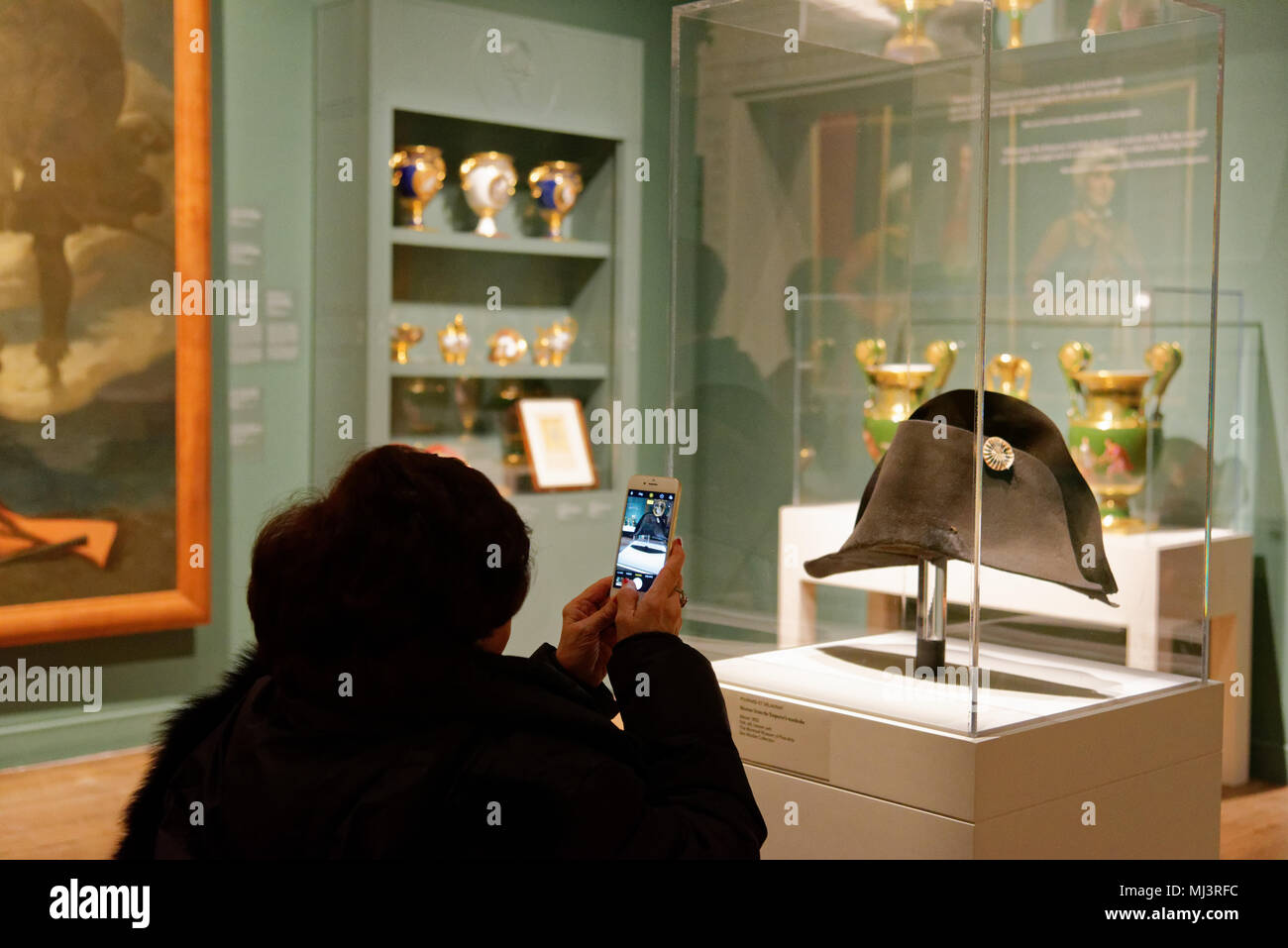 A woman taking a picture of Napoleons two cornered hat in a display in Montreal Fine Art Museum Stock Photo