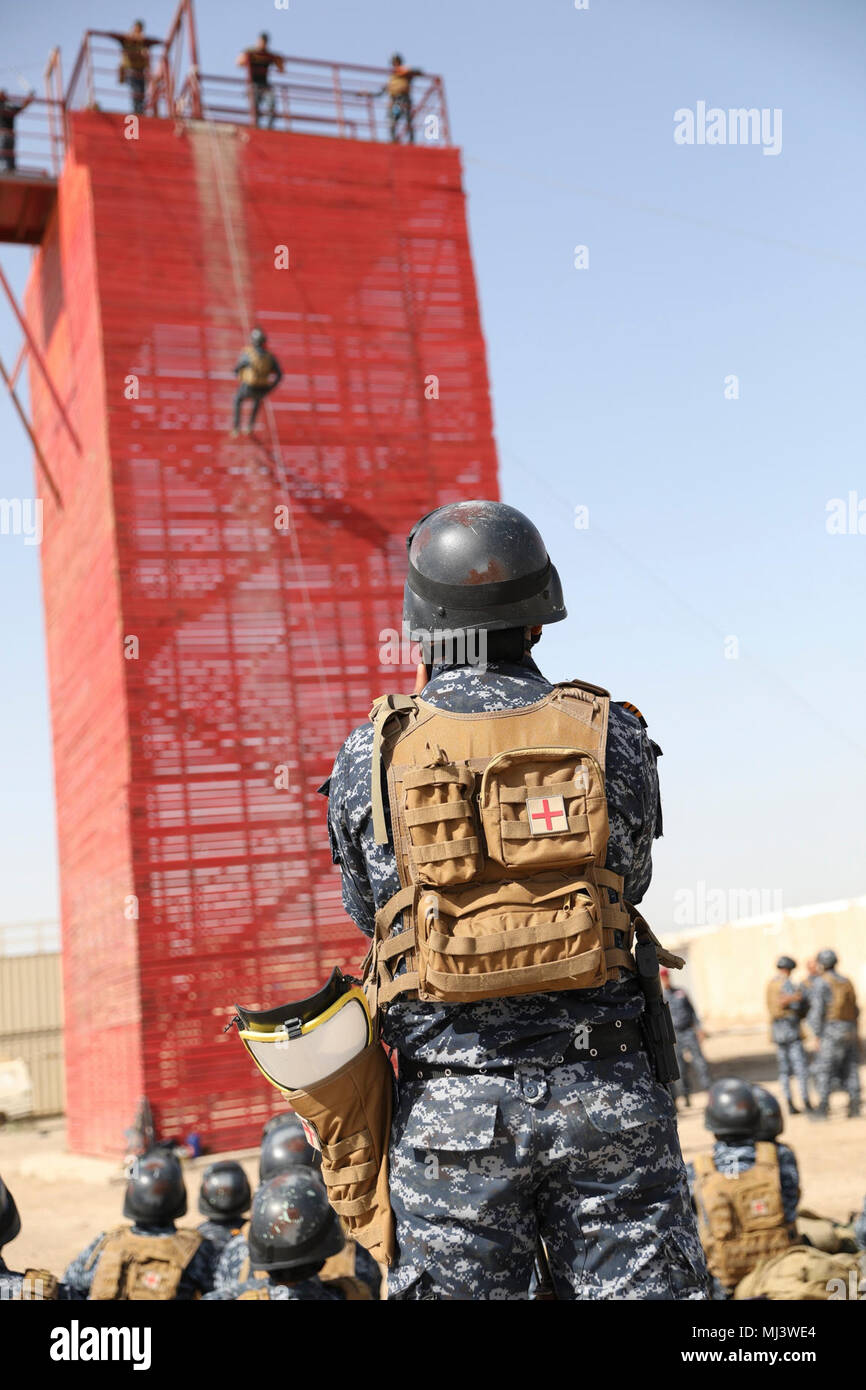 An Iraqi federal police member watches a fellow student rappel down a tower during training at Camp Dublin, Iraq, March 20, 2018. This training is part of Operation Inherent Resolve, the Global Coalition’s military campaign to defeat ISIS in Iraq. (U.S. Army Image collection celebrating the bravery dedication commitment and sacrifice of U.S. Armed Forces and civilian personnel. Stock Photo