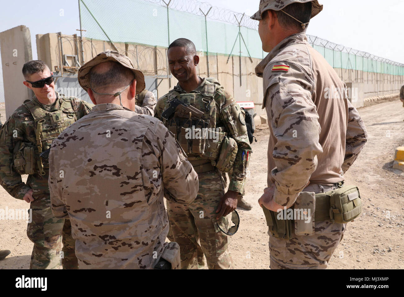 U.S. Army Command Sgt. Maj. Michael Crosby (center) Combined Joint Task Force – Operation Inherent Resolve command sergeant major, and Command Sgt. Maj. Samuel Roark (left), talk with Task Force Besmaya leaders at the Besmaya Range Complex, Iraq, March 21, 2018. The purpose of the visit was to get an update on the current and ongoing training missions in the area. Operation Inherent Resolve is the Global Coalition’s military campaign to defeat ISIS in Iraq and Syria. (U.S. Army Image collection celebrating the bravery dedication commitment and sacrifice of U.S. Armed Forces and civilian person Stock Photo