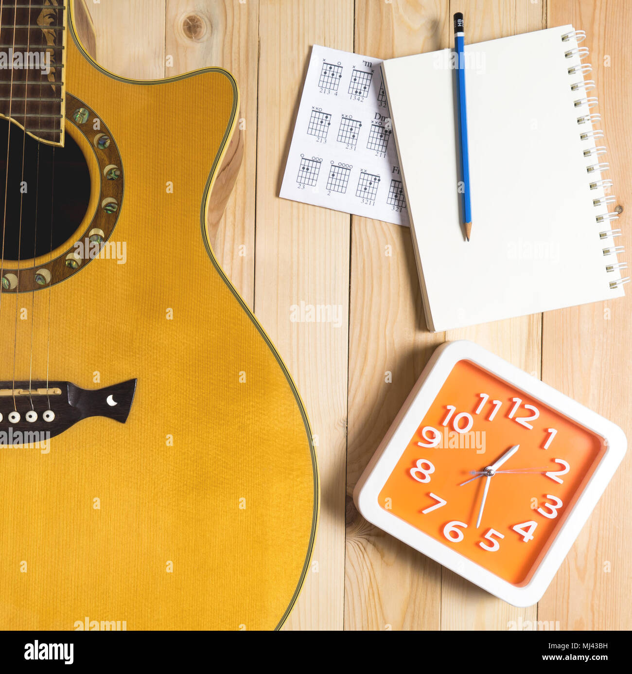 Time for Guitar song writing with a red clock Stock Photo Alamy
