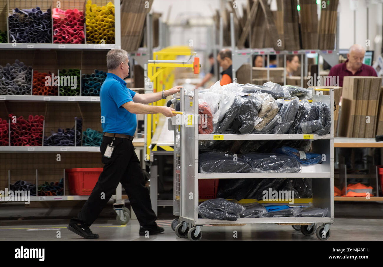 FILED - 07 December 2017, Germany, Bad Hersfeld: An Amazon employee pushes a cart on the company's media day. Amazon has announced the creation of  2000 new jobs in Germany, which would add up to a total of 18 000 employees nation-wide. Photo: Swen Pförtner/dpa Stock Photo