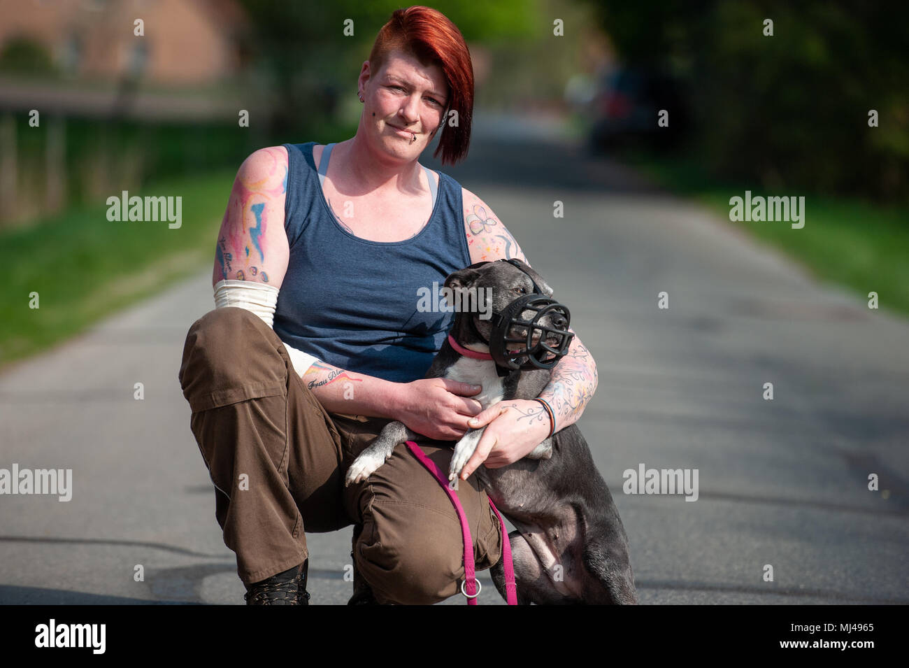 23 April 2018, Germany, Bispingen: Swantje Borrmann, employee of the 'Hellhound  Foundation', holds an American Staffordshire Terrier. The foundation cares  for and trains dogs who exhibit dangerous or abnormal behaviour. Photo:  Philipp