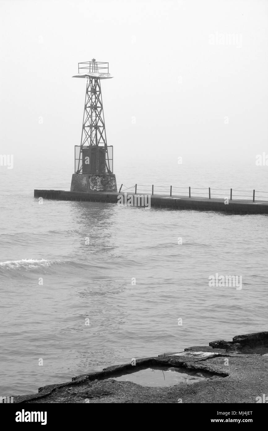 Fog and rain create poor visibility at the Foster Avenue Beach break wall signal tower on Lake Michigan in Chicago's north side Uptown neighborhood Stock Photo