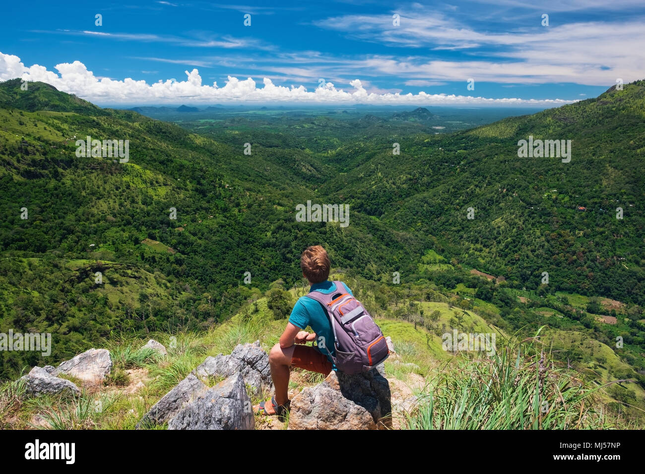 Caucasian hiker man take a rest on mountain peak with backpack. Stock Photo