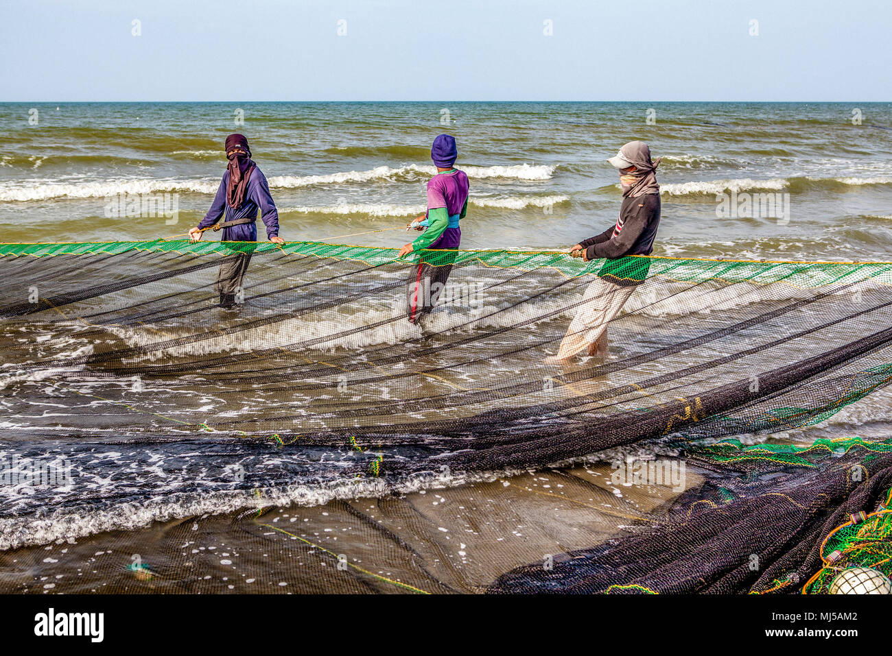 Fishermen from a local village near Baybay Beach set out and haul in their seine net twice a day to provide food and income for their families at Roxa Stock Photo