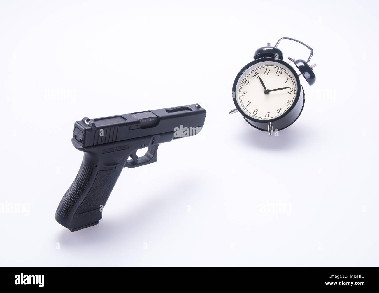 alarm clock with guns. alarm clock with guns on background Stock Photo