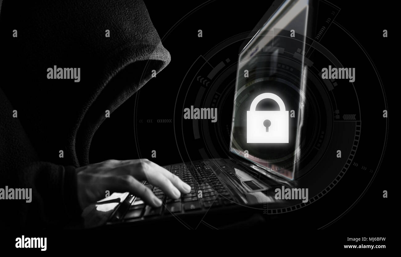 Internet network security system. Hacker in black hoodie using computer laptop Stock Photo