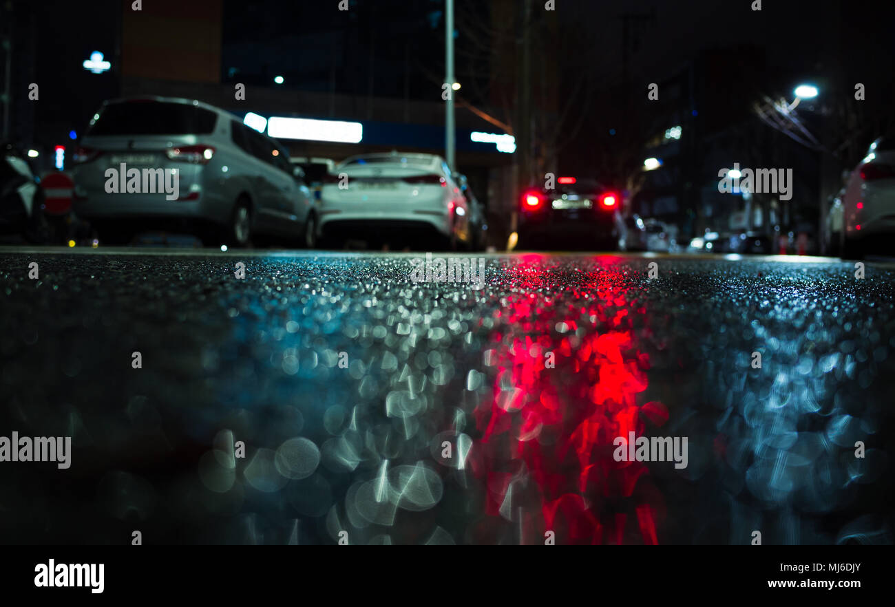 Abstract night city background with red stop lights reflection on wet ...