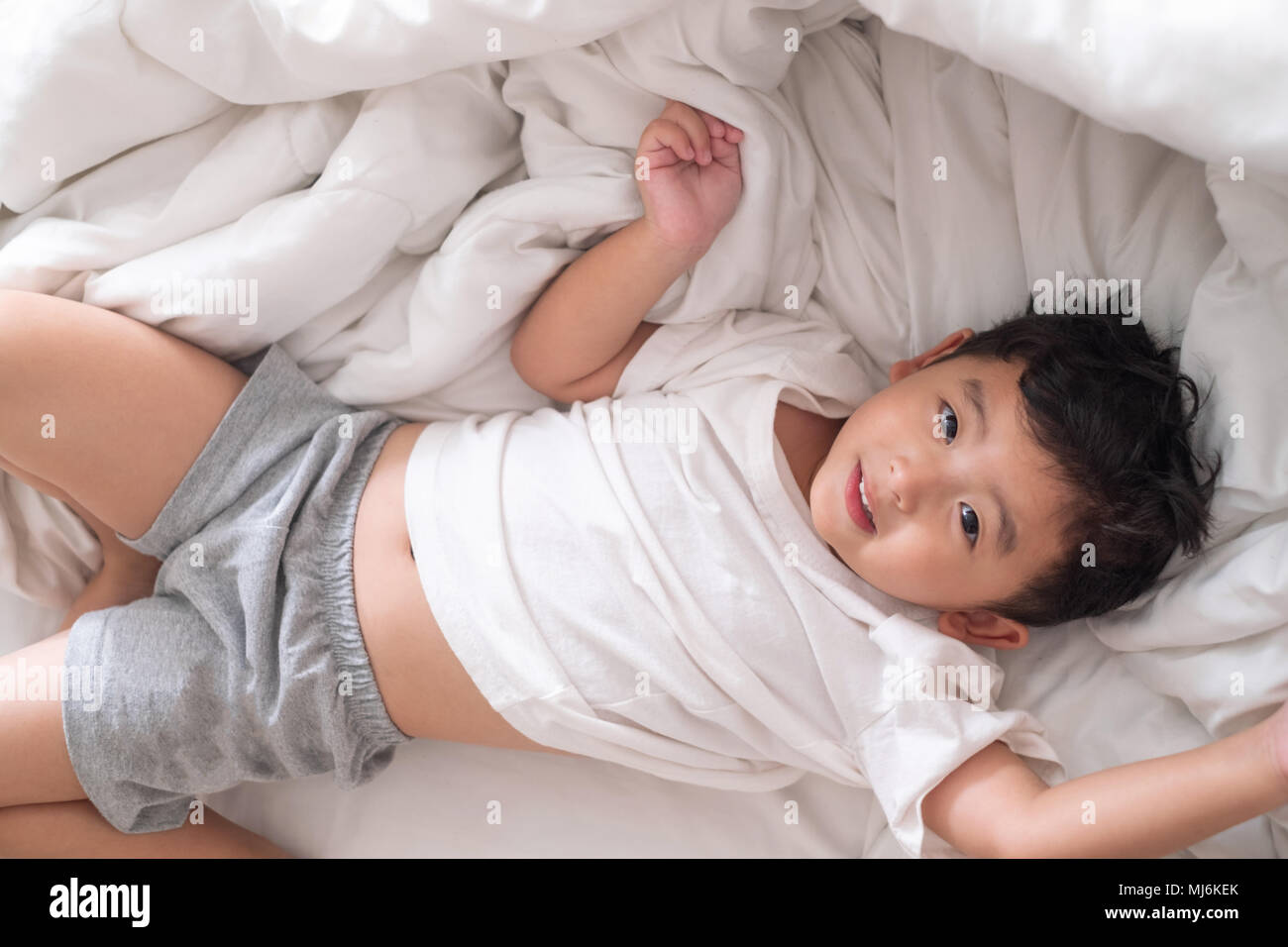Мальчики 12 лет спят. Кровать для детей. Азиатский мальчик на кровати. Кровать для мальчика.