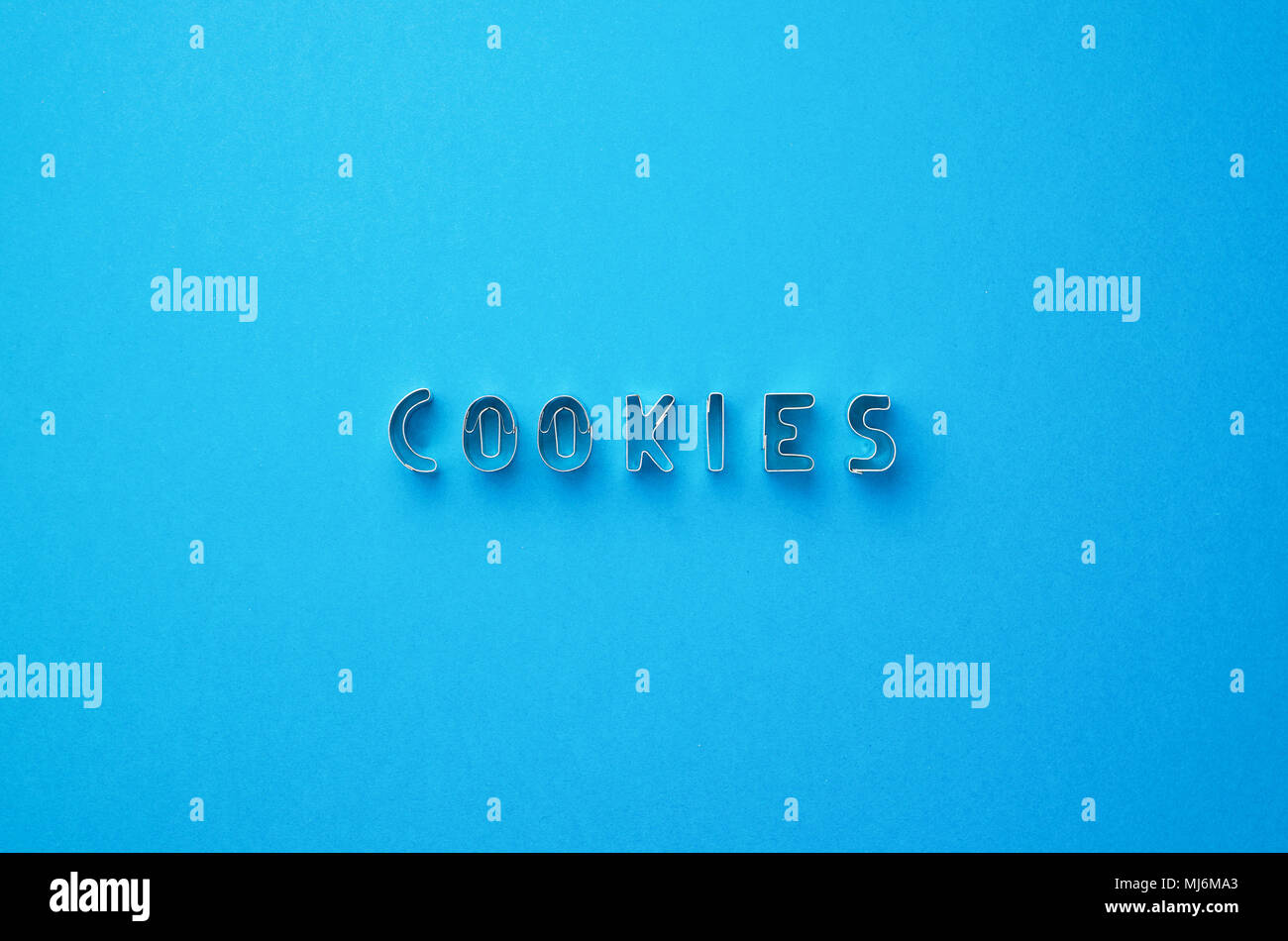 Cookies word written with cookie cutters molds over blue background, top view Stock Photo