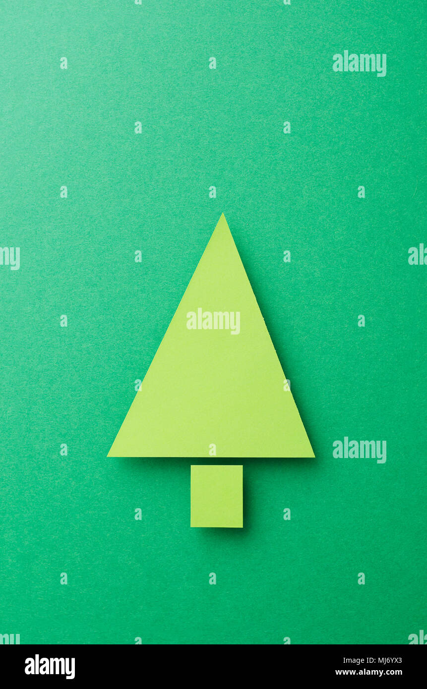 Paper Christmas Tree cut from green paper over green background, top ...