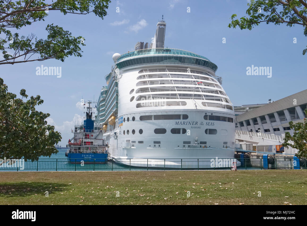 Singapore / Singapore - April 9 2018: A tow boat is preparing to tow the Royal Caribbean Ship 'The Mariner of the Seas' out of the passenger terminal Stock Photo