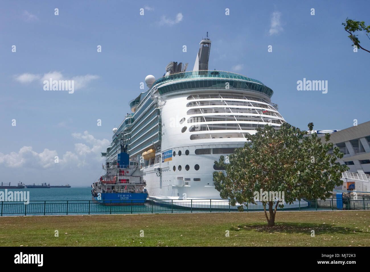 Singapore / Singapore - April 9 2018: A tow boat is preparing to tow the Royal Caribbean Ship 'The Mariner of the Seas' out of the passenger terminal Stock Photo