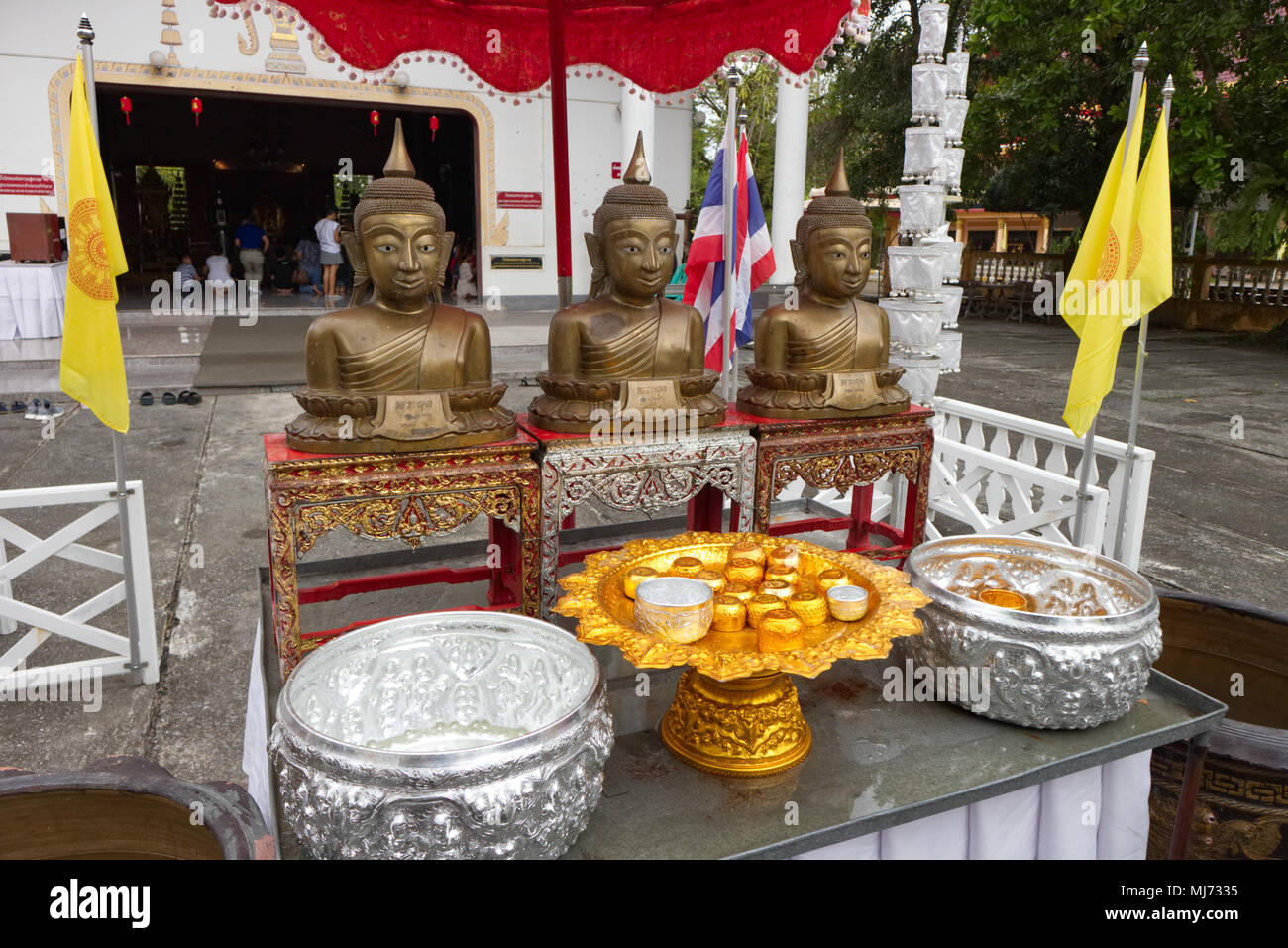 Thaland, Phuket / Thailand - April 11 2018 : Statues of Buddha are resting on a table in front of the Wat Phra Tong temple for worshippers to offer th Stock Photo
