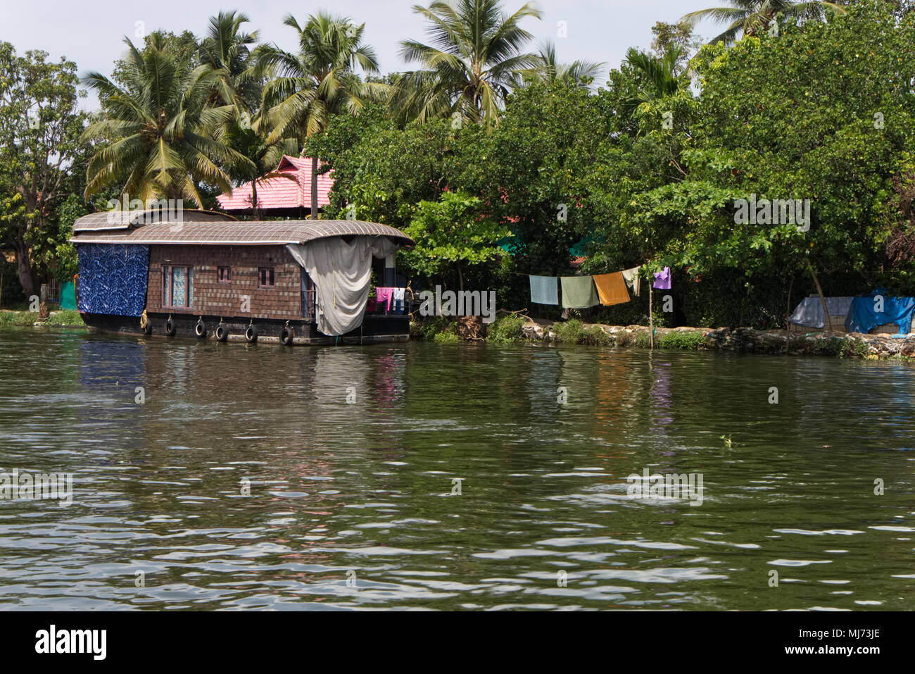 Alappuzha, Kerala / India - April 15 2018 : A tourist house boat is docked to one of the banks of the Alappuzha waterways. Stock Photo
